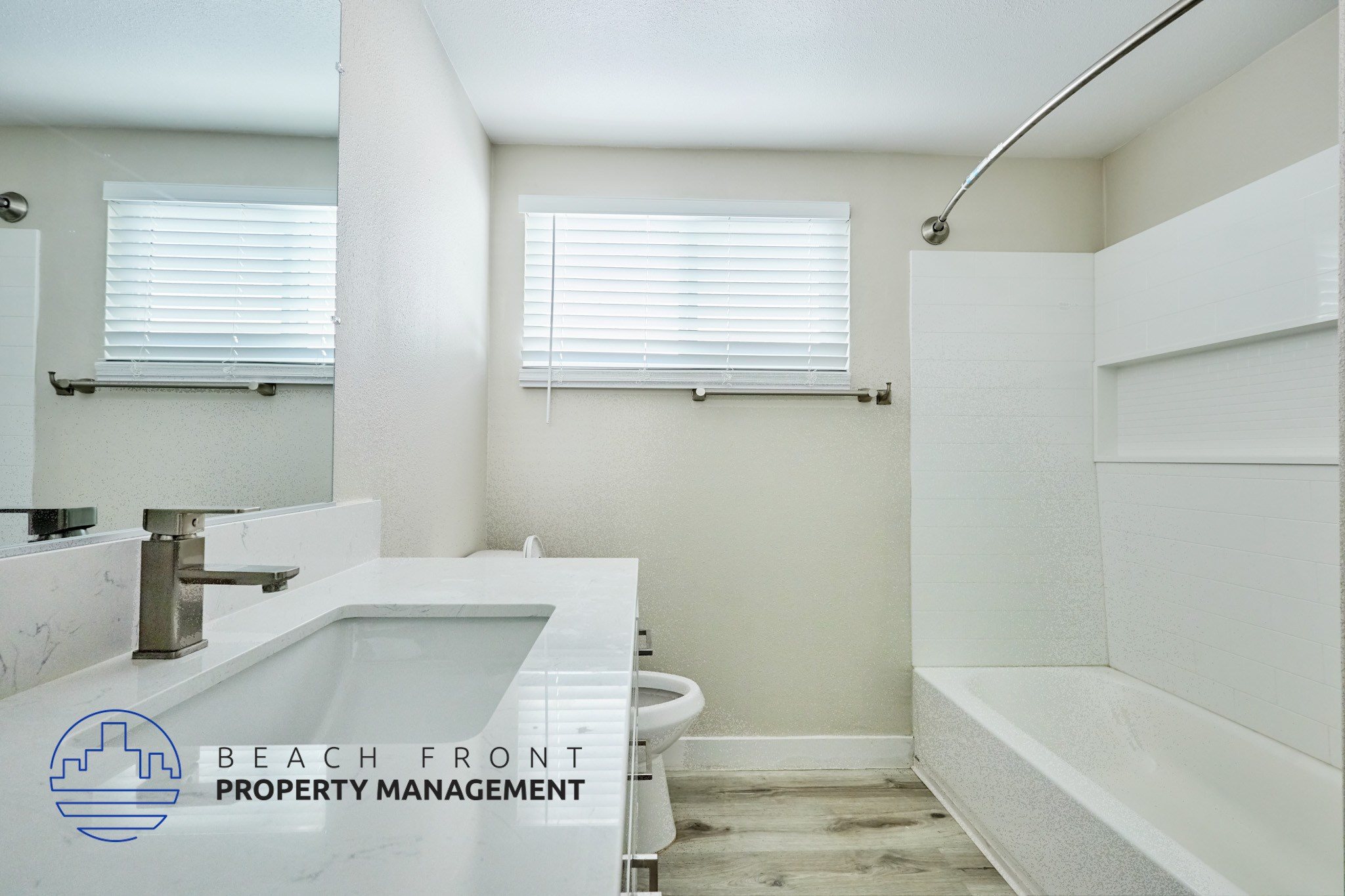 A bathroom with a marble sink and a window with blinds.